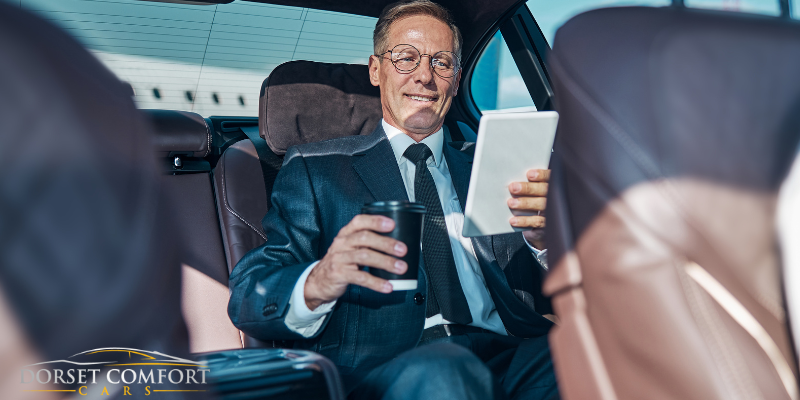 A happy businessman travelling in the back of a car.