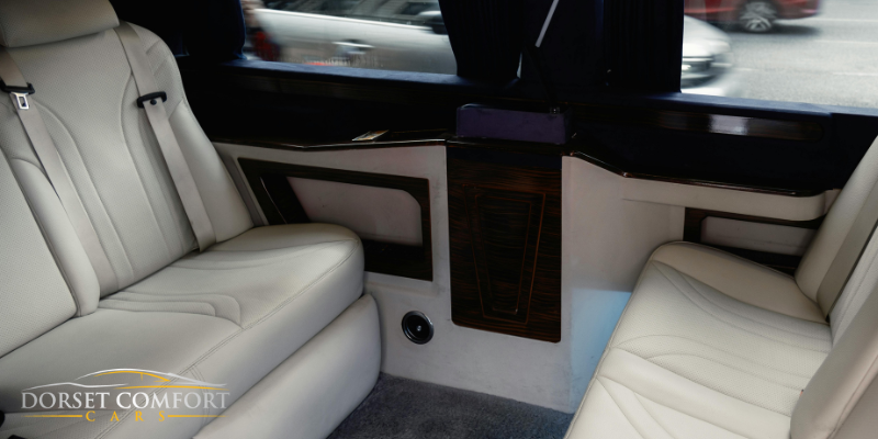 A picture of very comfortable car interior seen through an open door.